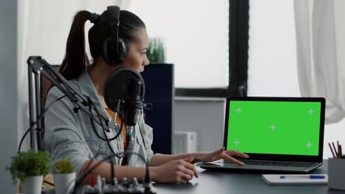Influencer in Studio Presenting Product on Laptop with Green Screen Background