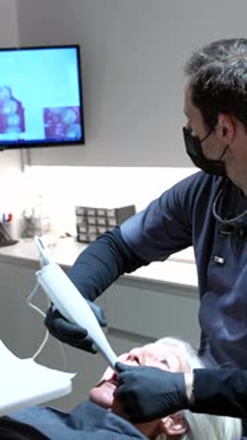 Dentist Scanning Patient's Teeth with Intraoral Scanner in Modern Clinic