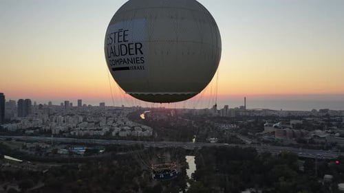 Aerial Shot Of Hot Air Balloon Descending Over Yarkon Park Against Sky In City