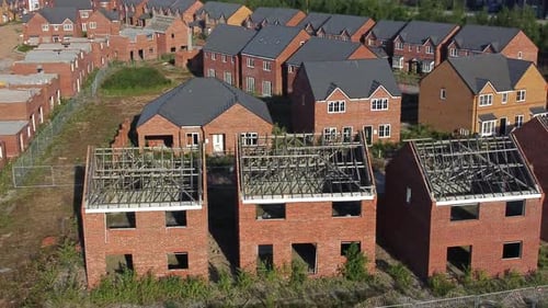Residential housing estate aerial view circling above unfinished property framework on building deve