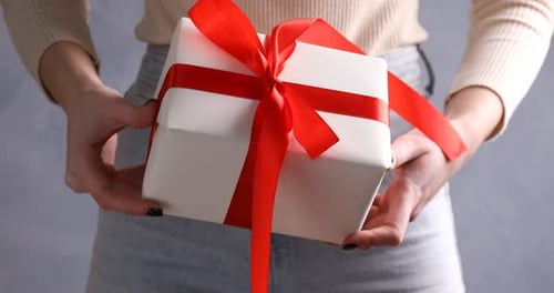 Woman Holding Gift Wrapped with Red Ribbon
