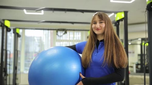 Woman Toning Waist Thigh with Electric Blue Exercise Ball in Gym