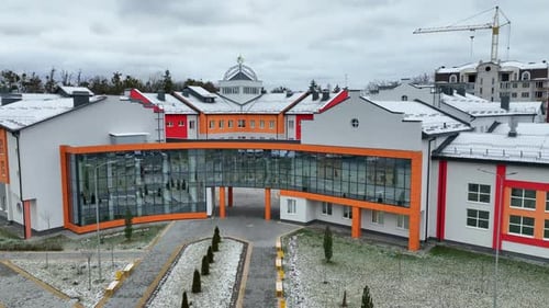 Front entrance to the building of unusual shape with mirrored windows.
