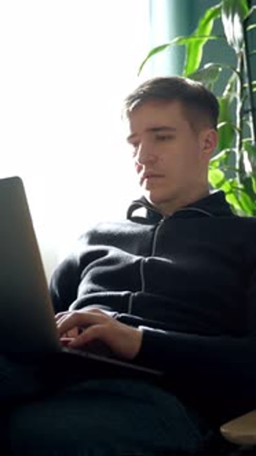Young Adult Man Working on Laptop Indoors