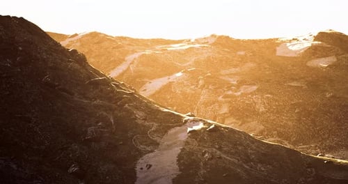 Golden Hour Sunlight Illuminates Rugged Mountain Landscape at Dusk