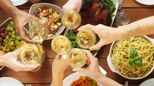 Friends Clinking Wine Glasses Above Feast