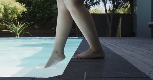 Niedriger Teil einer birazialen Frau, die in Zeitlupe im Schwimmbad läuft