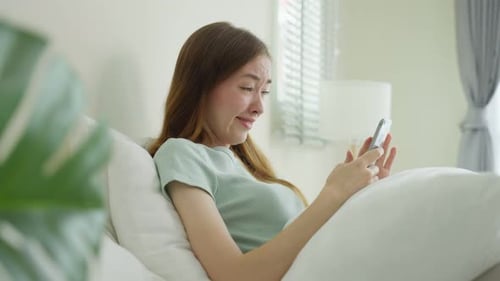 Woman Using Phone in Bed, Smiling
