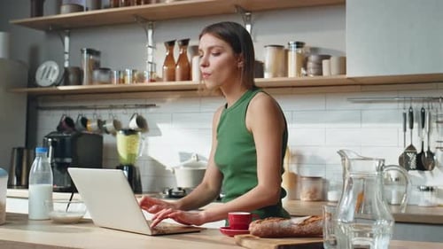 Woman Uses Laptop in Bright Kitchen