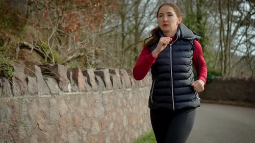 Brisk Walking Woman Training Along Stone Wall in Park Sport Walking Workout Burning Calories and