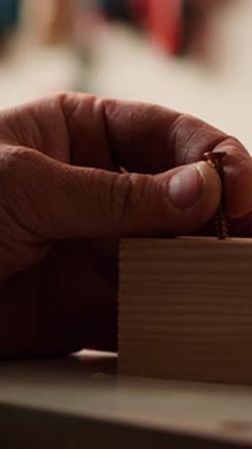Vertical Video Carpenter Sinks Screws Into Wooden Surfaces with Power Drill Close Up