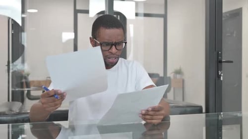 Concerned Man Reading Documents in Office