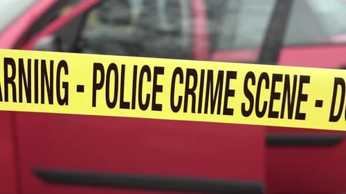 Police Crime Scene Tape RIbbon in Front of Red Car WIth Open Doors, Close Up