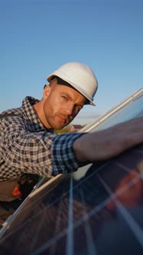 Worker Inspects Solar Panel After Installation