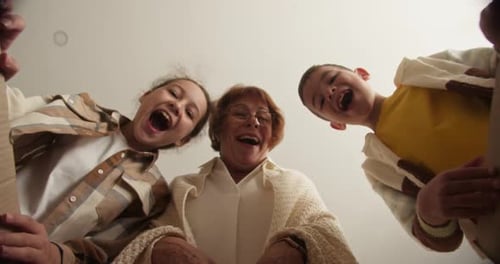 Grandmother and Children Excitedly Look Into Box