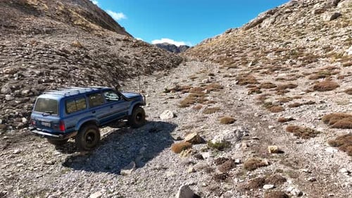 Aerial View Of Offroad Vehicle Climbing Mountain