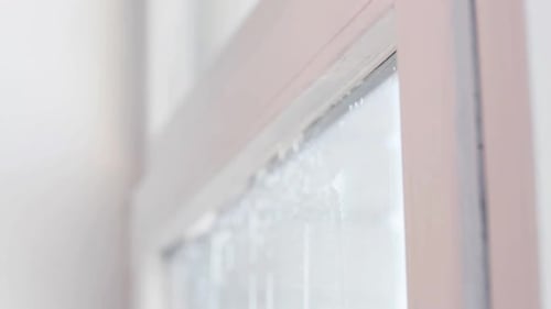 Cleaning window with sponge tool indoors close-up