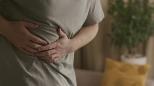 Close Up of Man Pressing Hands against His Abdomen in Pain