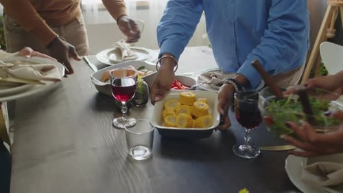 People Setting Up a Table With Plates and Food