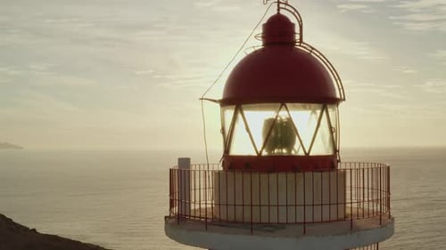 Primer plano de un Zumbido de un faro con el sol y el océano de fondo en la hora dorada
