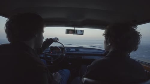 Couple Sitting inside Car, Looking out over Frozen Lake at Dusk