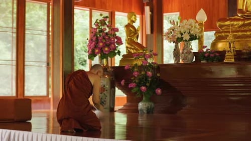 A Monk Bows Down to the Buddha Statue in the Temple During a Religious Ceremony
