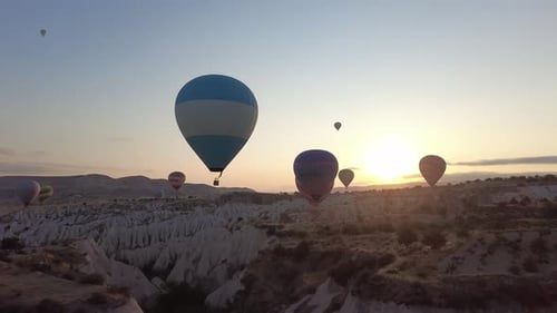 Hot Air Balloons Over Rocky Desert at Sunrise