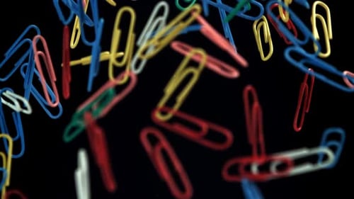 Colorful Paperclips Floating on a Black Background