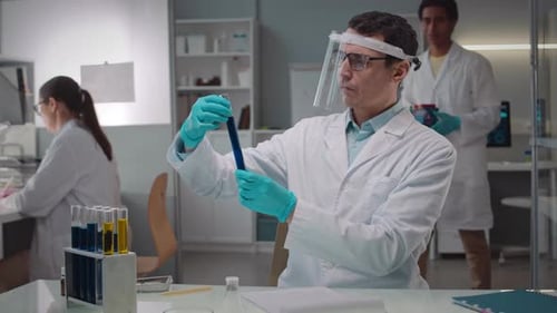 Scientist Analyzing Liquid in Test Tubes in Laboratory