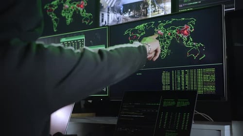 Hooded Hacker in Front of Multiple Monitors