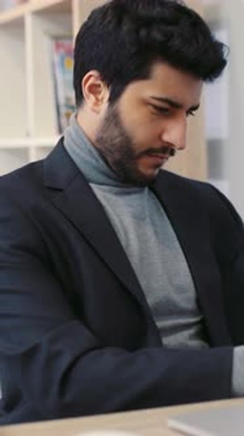 A Stylish Man in a Suit Works at a Modern Desk Exuding Confidence