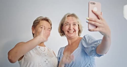 Two Young Satisfied Happy Daughter Mother Together Couple Women in Casual Beige Clothes Point Index