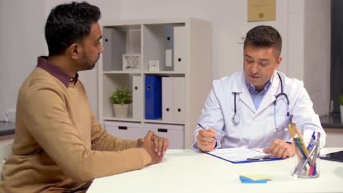 Doctor discusses health problem with young patient at hospital medical office