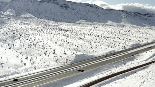 Autobahn durch schneebedeckten Berghang, LKW-Seitenansicht aus der Luft