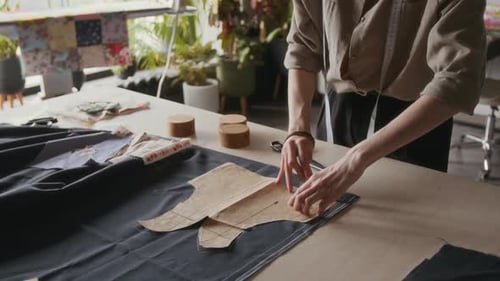 Young Seamstress Drawing Pattern on Fabric for Bespoke Fashion Garment