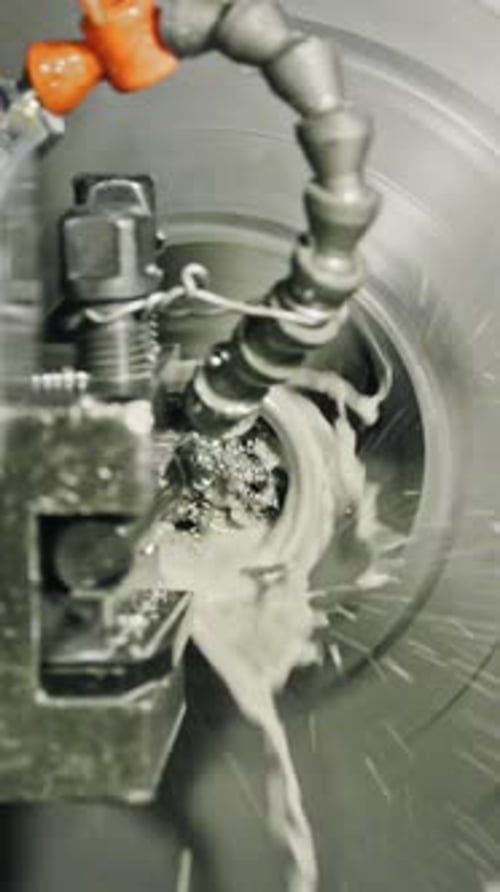 Precision metal cutting with industrial lathe machine and coolant fluid