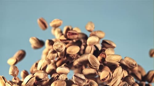 Pistachios Falling in Slow Motion on Blue
