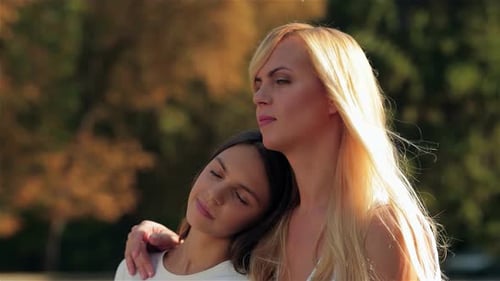 Tender Embrace Between Mother and Daughter in a Sunlit Park