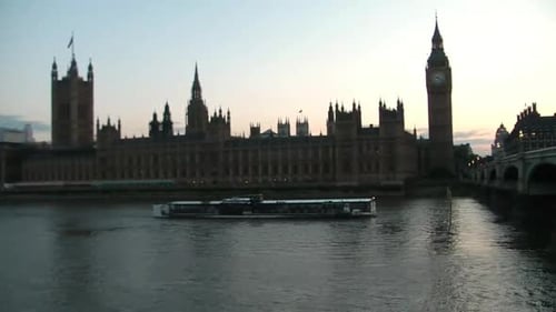 Um barco com turistas está passando por baixo da ponte sobre o Tâmisa, perto do Palácio de Westminster em Lon