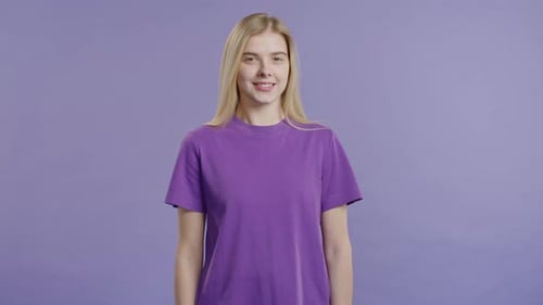 Young Woman Smiling in Front of Purple Background
