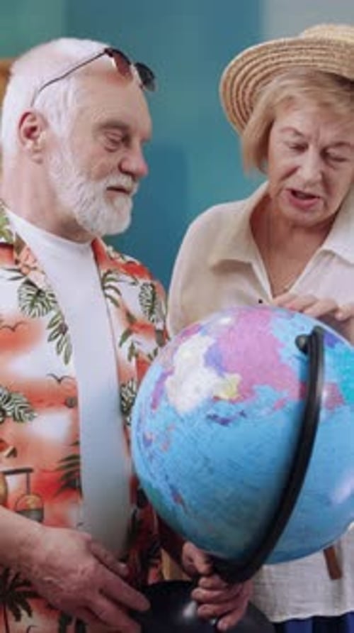 Senior Couple Planning Vacation with Globe