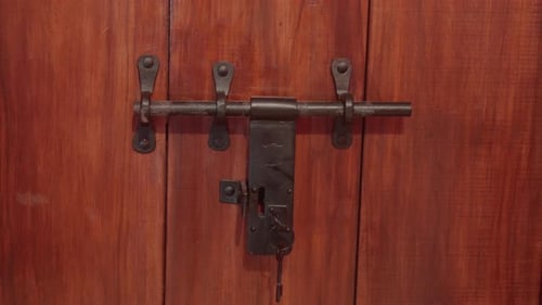 Rustic wooden door with an old metal lock and latch in close-up view