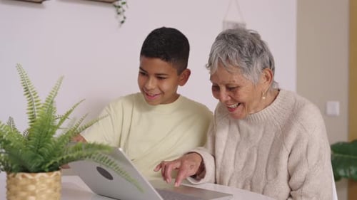 Boy and Senior Woman Looking at Laptop Indoors