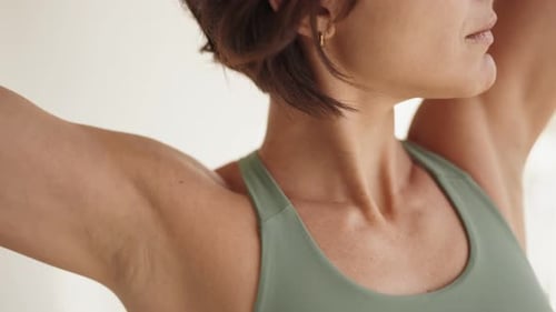 Woman Stretching Arms Behind Head Indoors