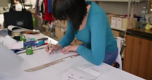Woman Designs Garment Patterns in Fashion Studio