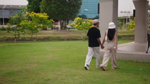 Tourists Enjoying a Relaxing Walk Through a Green Park in Thailand