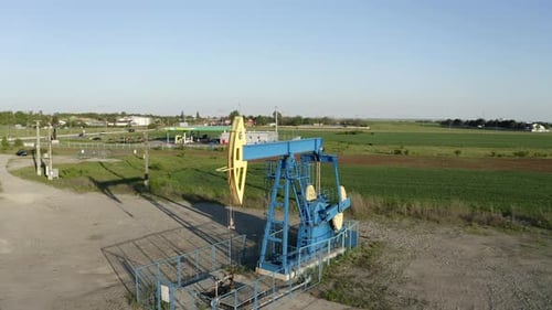 Massive Industrial Oil Pump Jack Working In Rural Countryside Fields