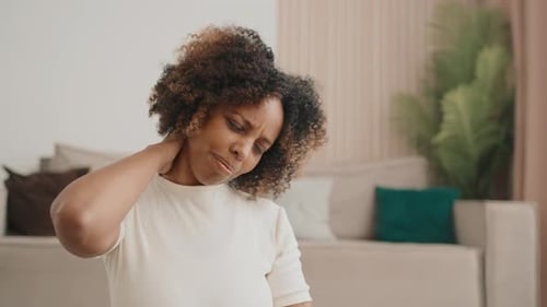 Schwarze Frau macht Nackengymnastik zu Hause Vorbeugung von Osteochondrose Erwachsener Afroamerikaner