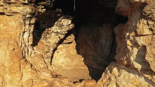 Sunlight Illuminating the Entrance of a Rocky Cave