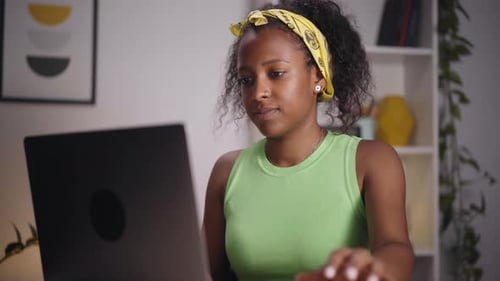 Young African Woman Using Laptop Home Office